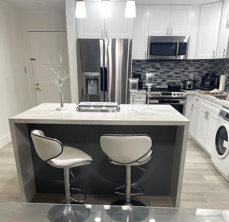 6950 Northwest 186th Street, Unit 2510 Hialeah, FL 33015 - Photo 7 of 19 a kitchen with stainless steel appliances granite countertop a dining table chairs sink and cabinets