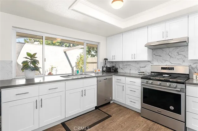 a kitchen with stainless steel appliances white cabinets and a sink