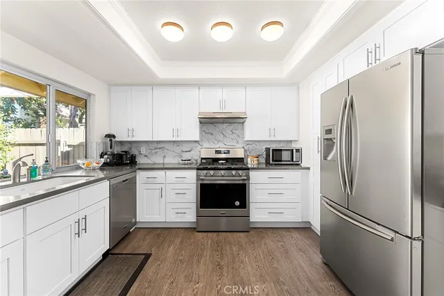 a kitchen with a refrigerator stove and white cabinets
