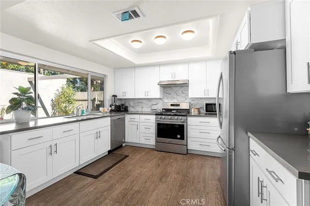 a kitchen with granite countertop white cabinets and white appliances