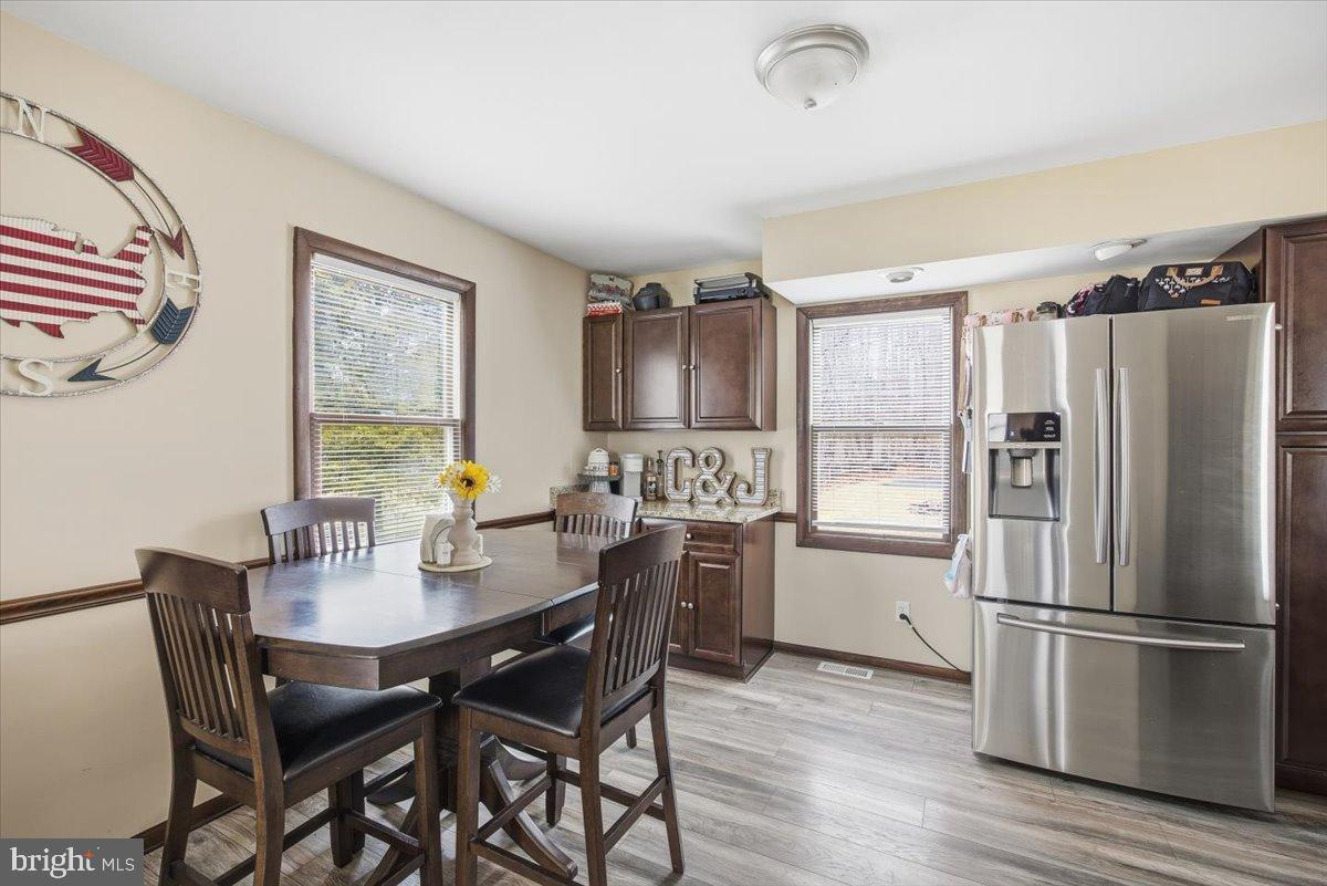 1518 Commissioners Road Mullica Hill, NJ 08062 - Photo 17 of 35 a kitchen with a refrigerator a stove a dining table and chairs