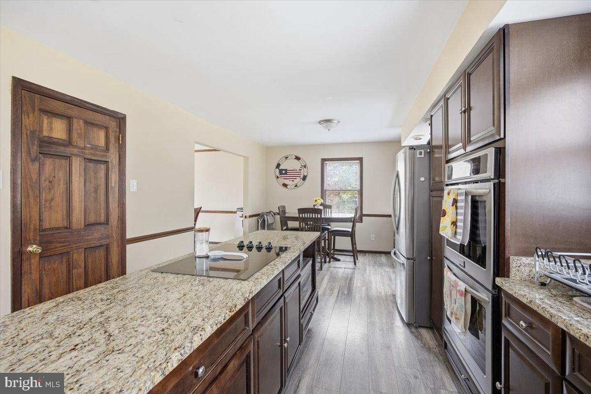 1518 Commissioners Road Mullica Hill, NJ 08062 - Photo 20 of 35 a kitchen with stainless steel appliances granite countertop lots of counter top space and wooden floor