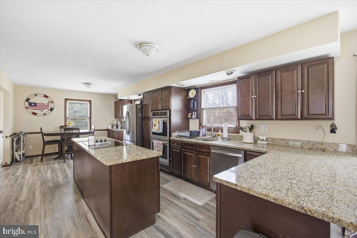 1518 Commissioners Road Mullica Hill, NJ 08062 - Photo 21 of 35 a kitchen with stainless steel appliances granite countertop a sink stove and refrigerator
