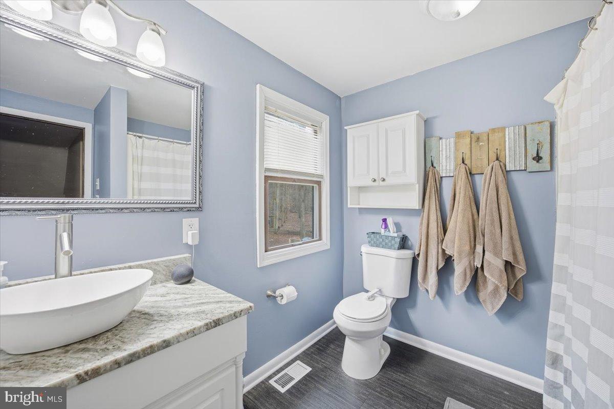 1518 Commissioners Road Mullica Hill, NJ 08062 - Photo 34 of 35 a bathroom with a granite countertop toilet a sink and a mirror