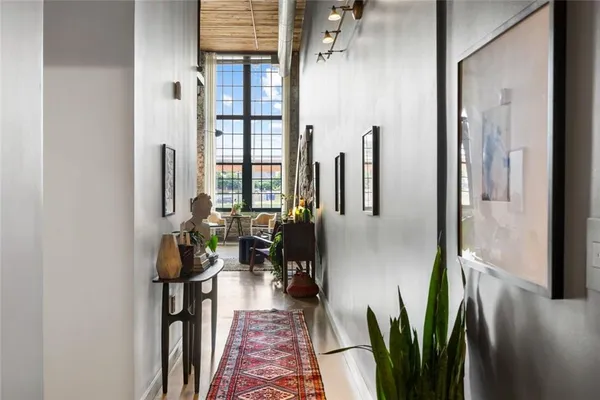 a hallway with painting on the wall and a potted plant