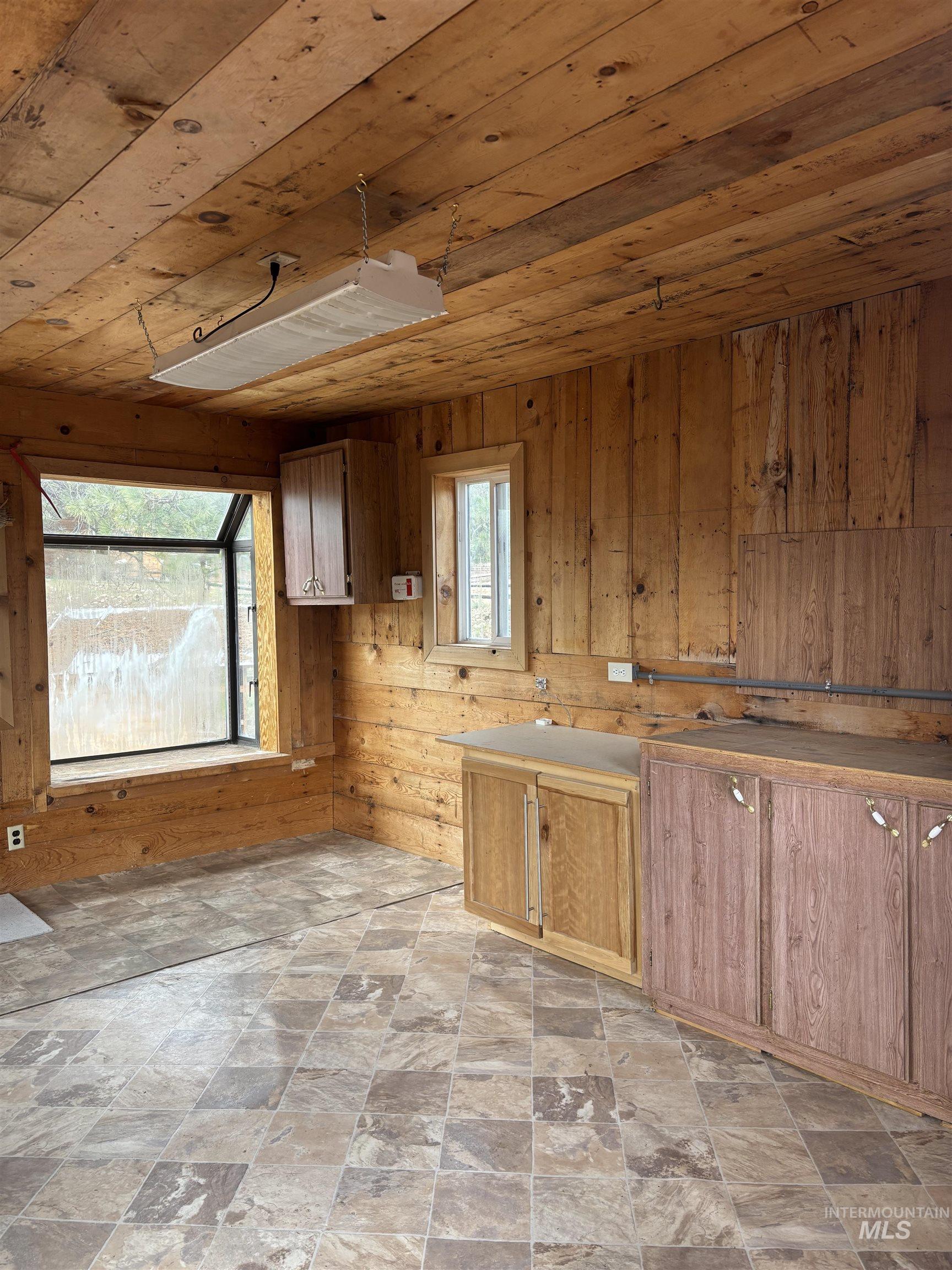 29 McIntyre Gulch Road Boise, ID 83716 - Photo 17 of 50 Wood-paneled room featuring a large picture window, a smaller vertical window, and wood-finish cabinetry