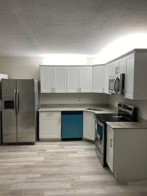 201 Foxtail Drive, Unit C2 Greenacres, FL 33415 - Photo 5 of 12 a kitchen with stainless steel appliances granite countertop a stove a sink and a refrigerator