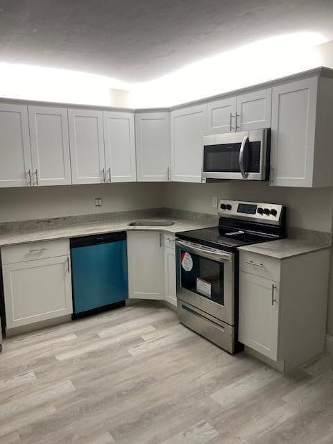 201 Foxtail Drive, Unit C2 Greenacres, FL 33415 - Photo 6 of 12 a kitchen with stainless steel appliances granite countertop a stove a sink and a microwave