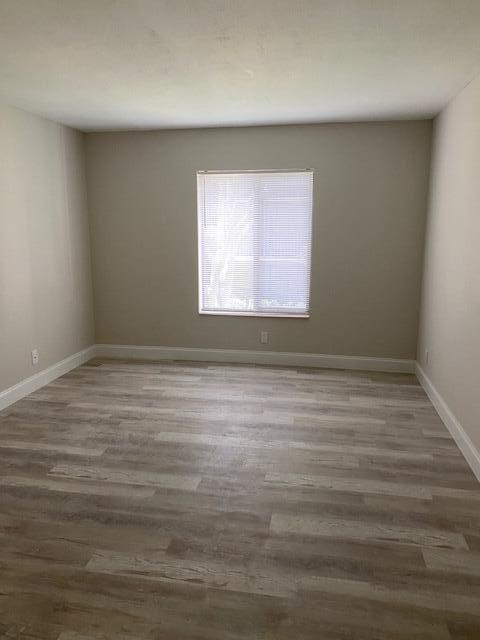 201 Foxtail Drive, Unit C2 Greenacres, FL 33415 - Photo 8 of 12 an empty room with wooden floor and windows