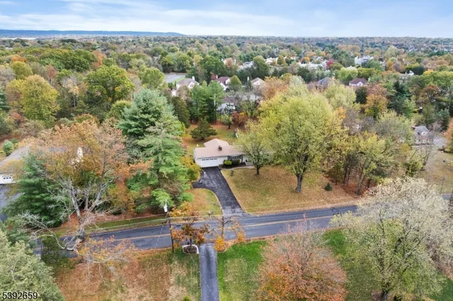 an aerial view of a house with a yard and lake view