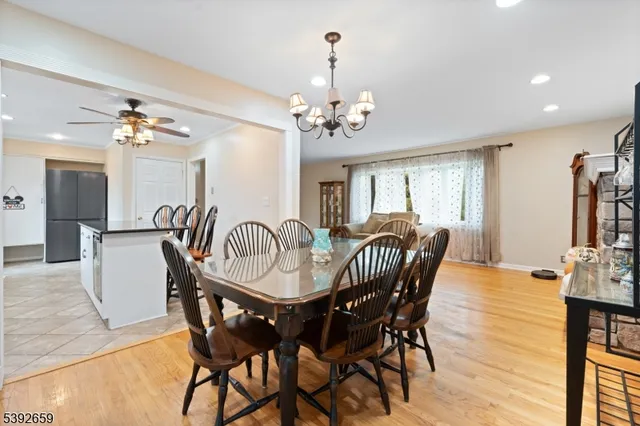 a view of a dining room with furniture a chandelier and wooden floor