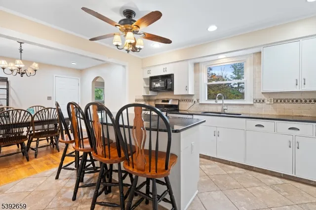 a very nice looking dining room with a large window a chandelier