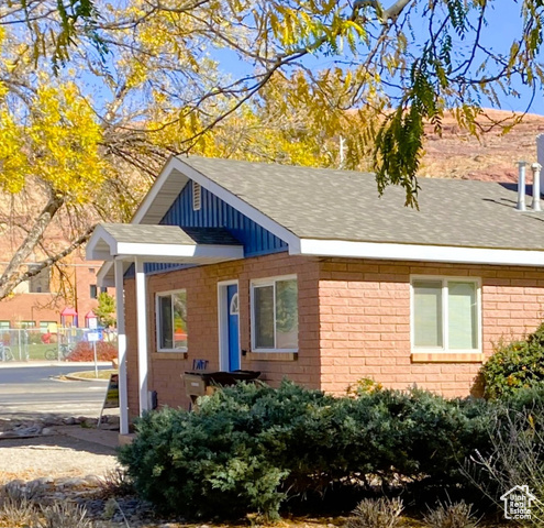 247 West 400 North, Unit 1 Moab, UT 84532 - Photo 6 of 27 View of side of home with brick siding and a shingled roof
