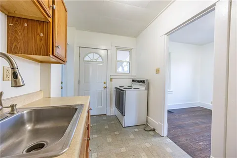 a kitchen with a sink and a stove top oven with wooden floor