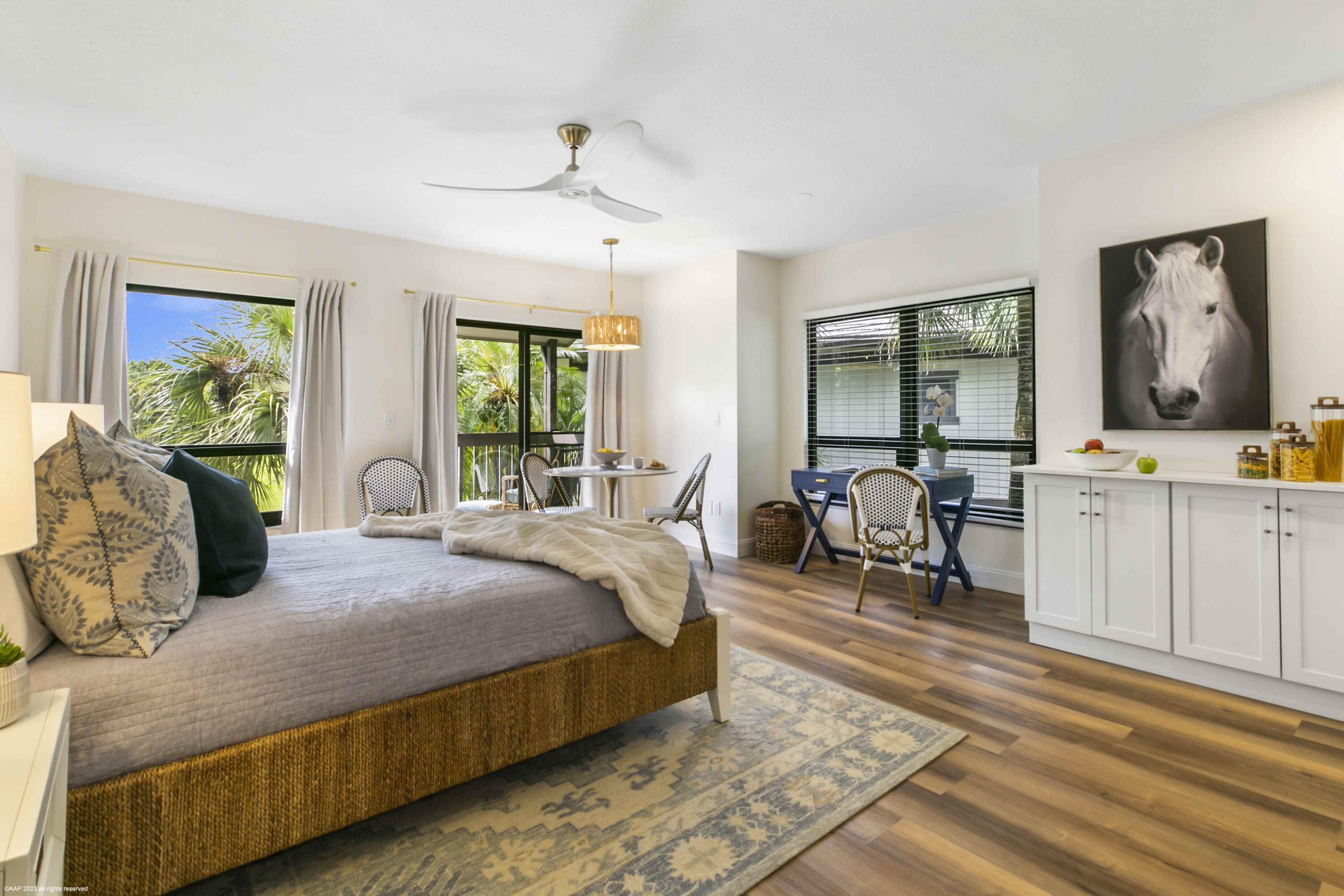 13334 Polo Club Road, Unit 347 Wellington, FL 33414 - Photo 2 of 15 a bedroom with a large bed and a chandelier