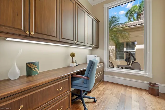 a view of a workspace with furniture and a window