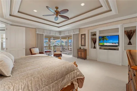 a bedroom with a large bed and a chandelier