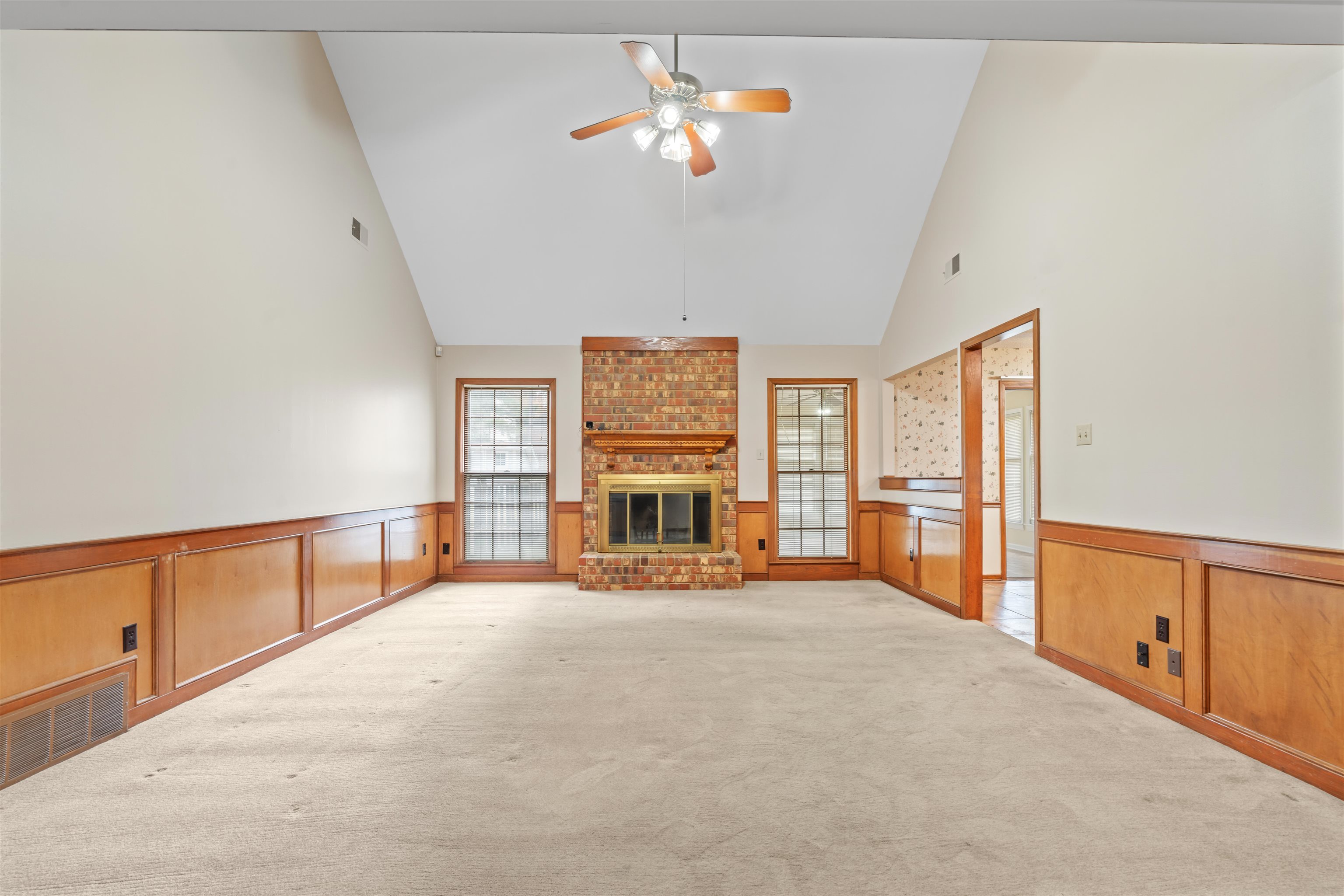 7087 Cutter Mill Road Memphis, TN 38141 - Photo 4 of 20 Spacious great room with ceiling fan, a fireplace, neutral light carpet, and high vaulted ceiling. There is a walk over balcony over the great room that leads to 2 expandable areas.