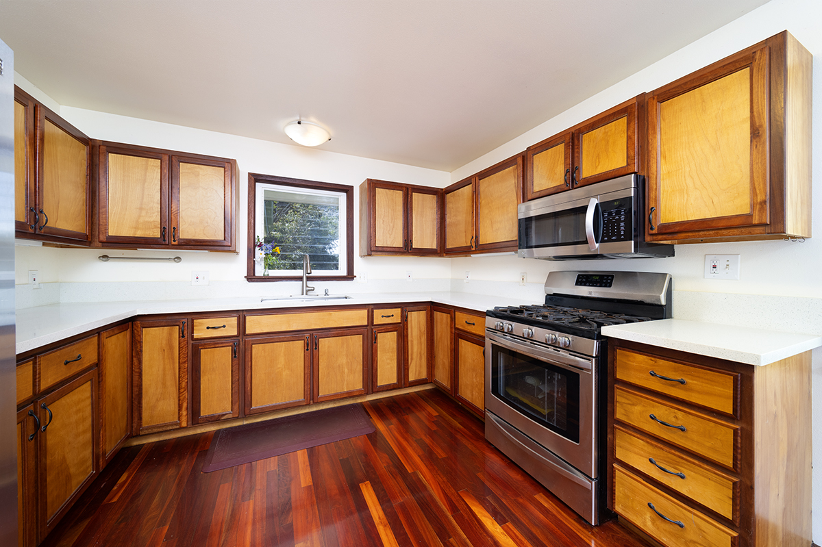 35-486 Pahale Road Papaaloa, HI 96780 - Photo 9 of 30 a kitchen with stainless steel appliances granite countertop wooden cabinets a stove a sink and a microwave