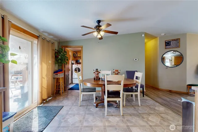 a dining room with furniture and a chandelier fan