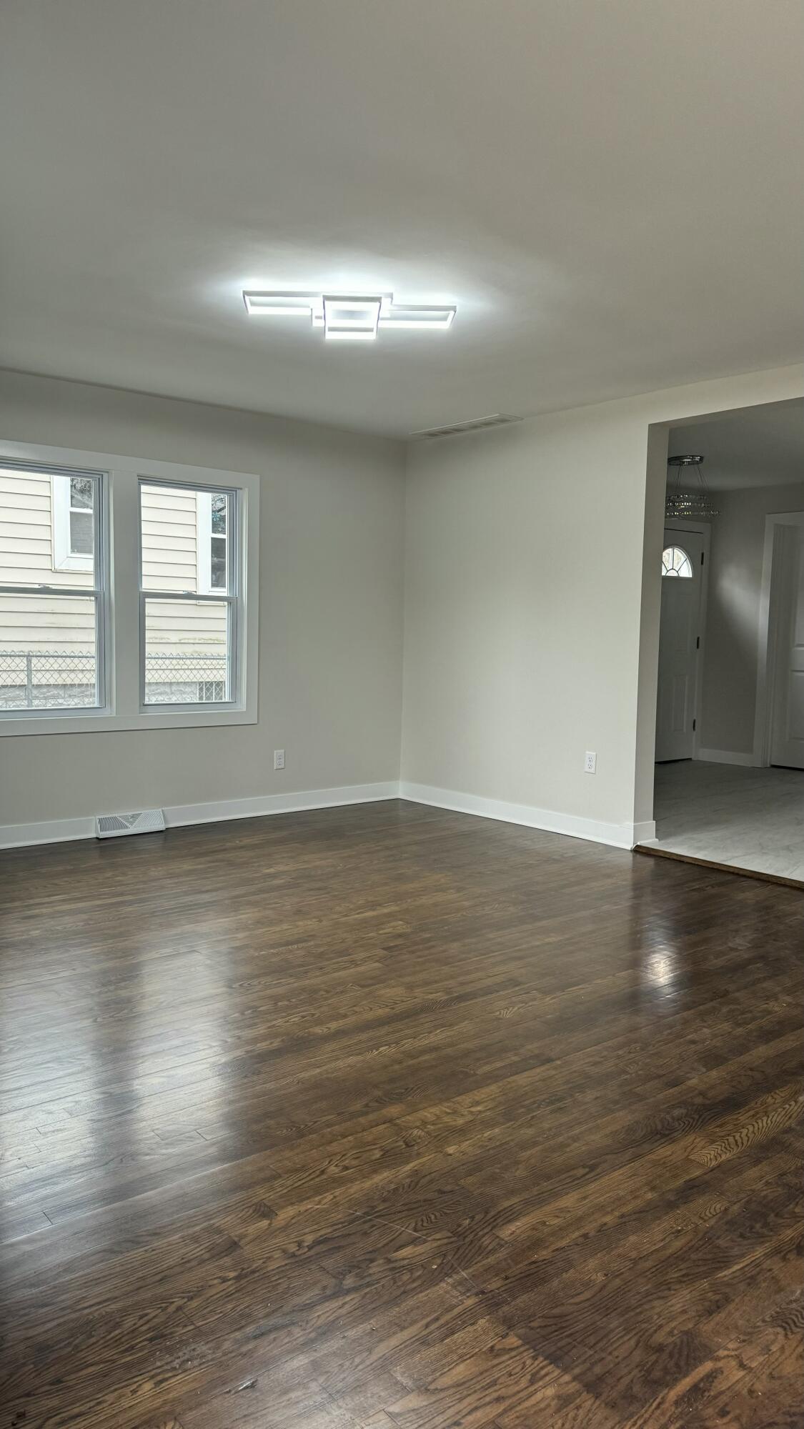 2926 State Street Lake Station, IN 46405 - Photo 4 of 16 an empty room with wooden floor and windows