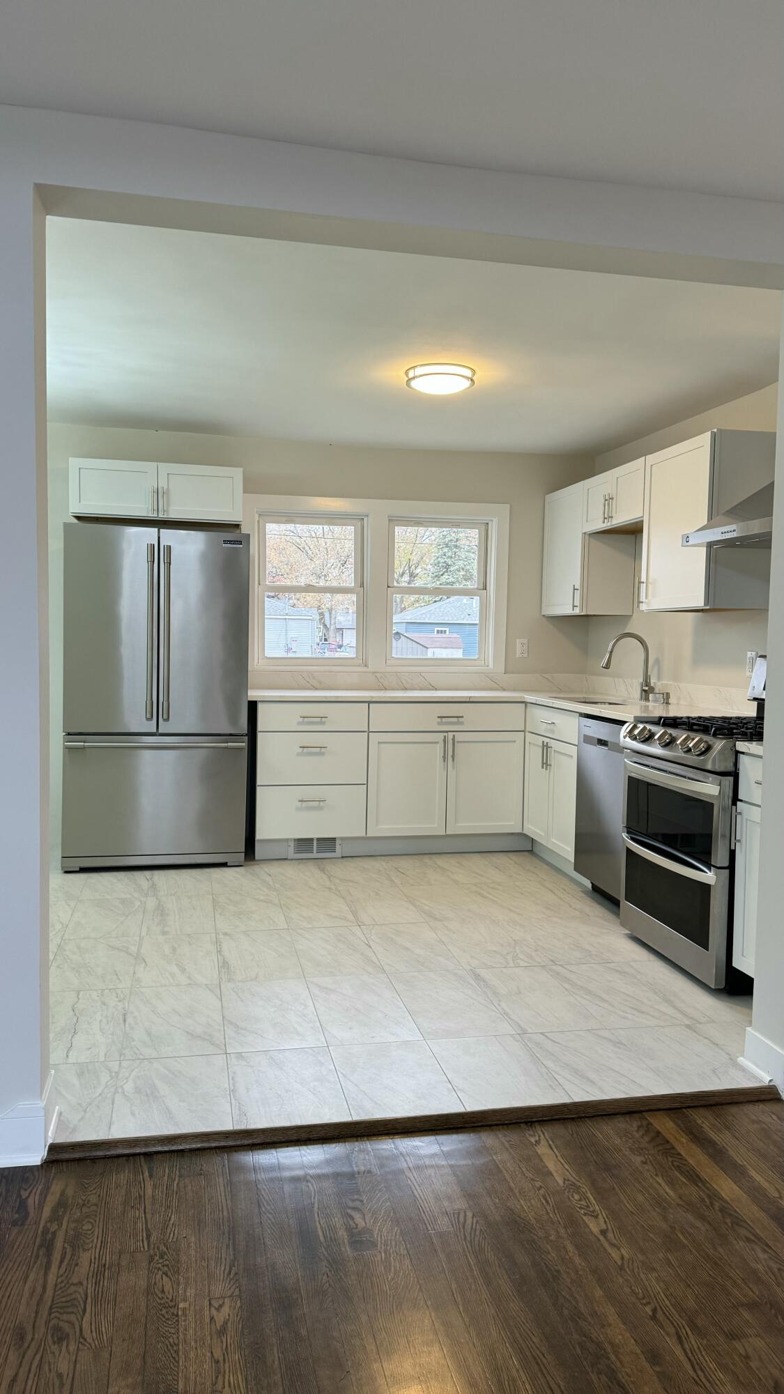 2926 State Street Lake Station, IN 46405 - Photo 8 of 16 a view of a kitchen with a stove cabinets and a wooden floor