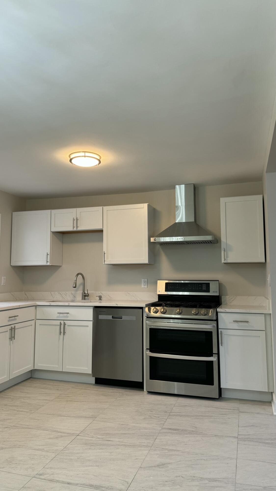 2926 State Street Lake Station, IN 46405 - Photo 10 of 16 a kitchen with stainless steel appliances a stove a sink and cabinets