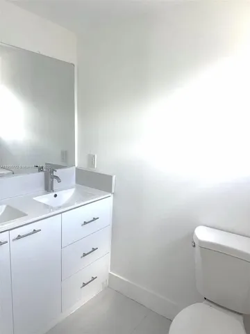 a bathroom with a toilet a sink and mirror