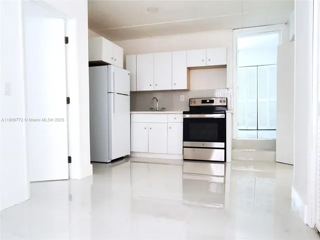 a kitchen with stainless steel appliances a stove a microwave and a sink