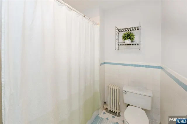 a bathroom with a toilet and a shower curtain