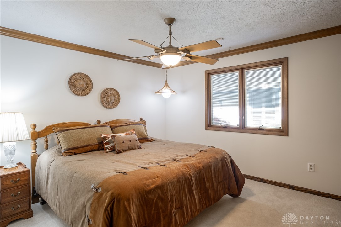 273 North Alpha Bellbrook Road Dayton, OH 45434 - Photo 28 of 43 This cozy bedroom features a ceiling fan, a window, and comfortable flooring, creating a relaxing atmosphere.