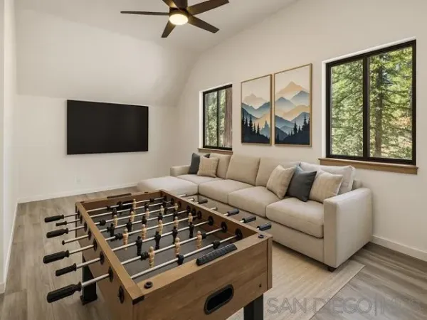a living room with furniture a flat screen tv and a window