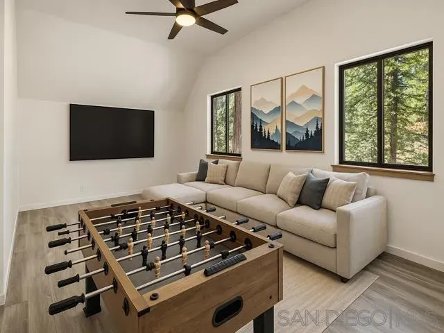 a view of a wooden house with large trees and wooden fence