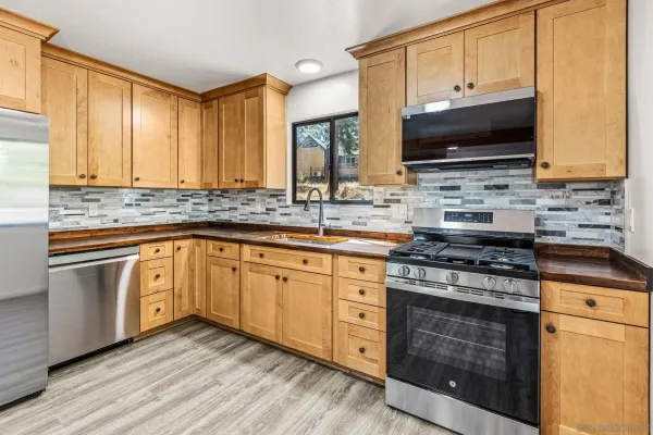 a kitchen with stainless steel appliances a stove a sink and a microwave