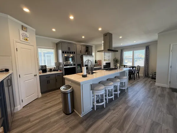 a kitchen with a sink a counter top space stainless steel appliances and cabinets