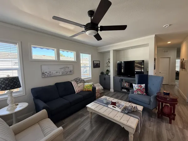 a living room with furniture a flat screen tv and a window