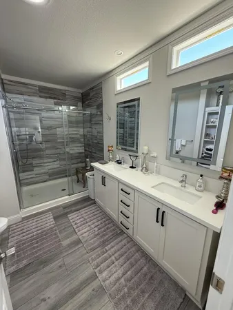 a large bathroom with a double vanity sink a mirror and a shower