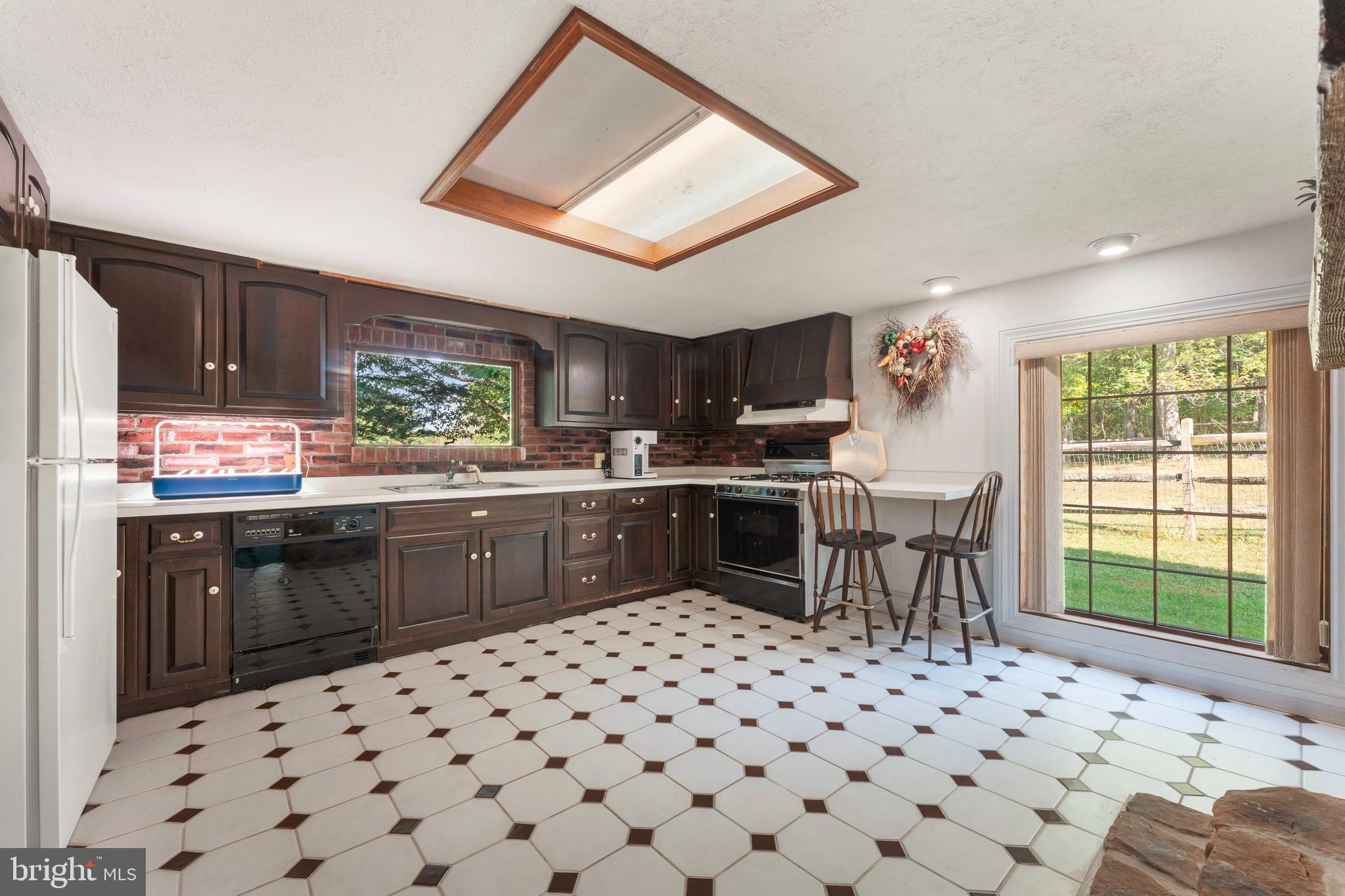 1390 Old Jacksonville Road Ivyland, PA 18974 - Photo 52 of 75 a kitchen with a sink a stove a microwave cabinets and dining table