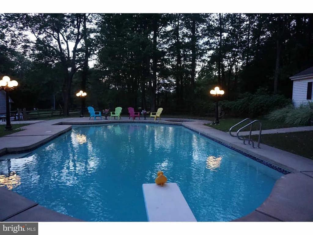 1390 Old Jacksonville Road Ivyland, PA 18974 - Photo 74 of 75 a view of swimming pool with outdoor seating and trees in the background
