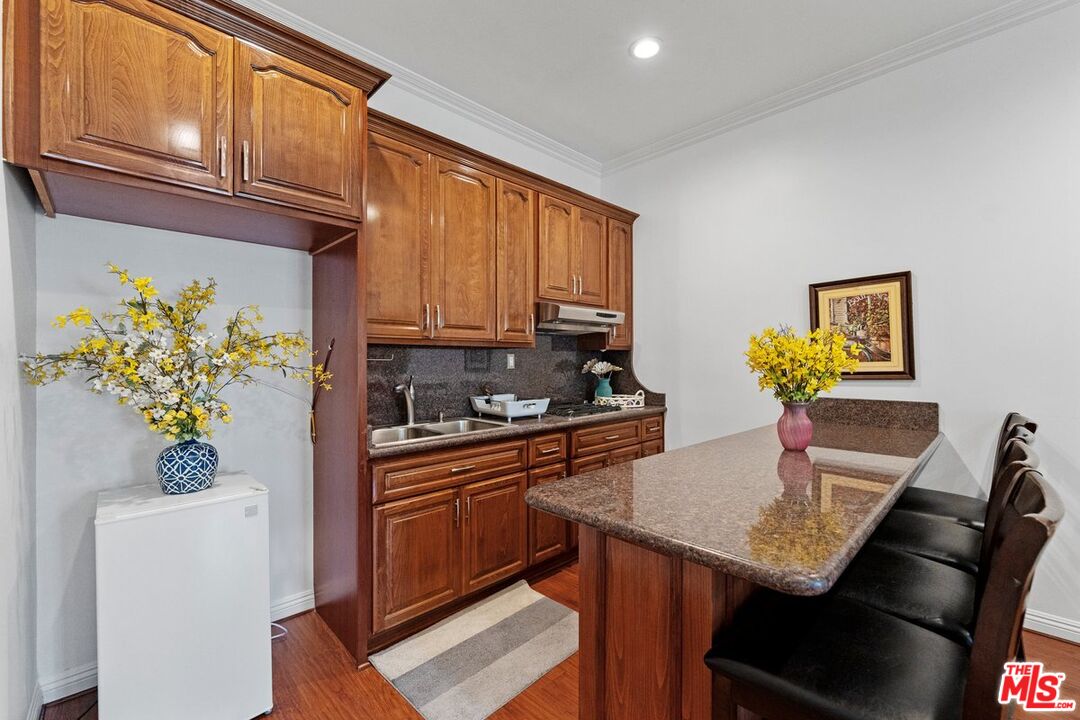 1430 North Dominion Avenue Pasadena, CA 91104 - Photo 17 of 25 a kitchen with stainless steel appliances granite countertop a refrigerator a stove a sink dishwasher and microwave with wooden floor