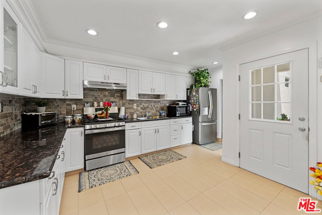1430 North Dominion Avenue Pasadena, CA 91104 - Photo 2 of 25 a kitchen with granite countertop a stove a sink and a refrigerator