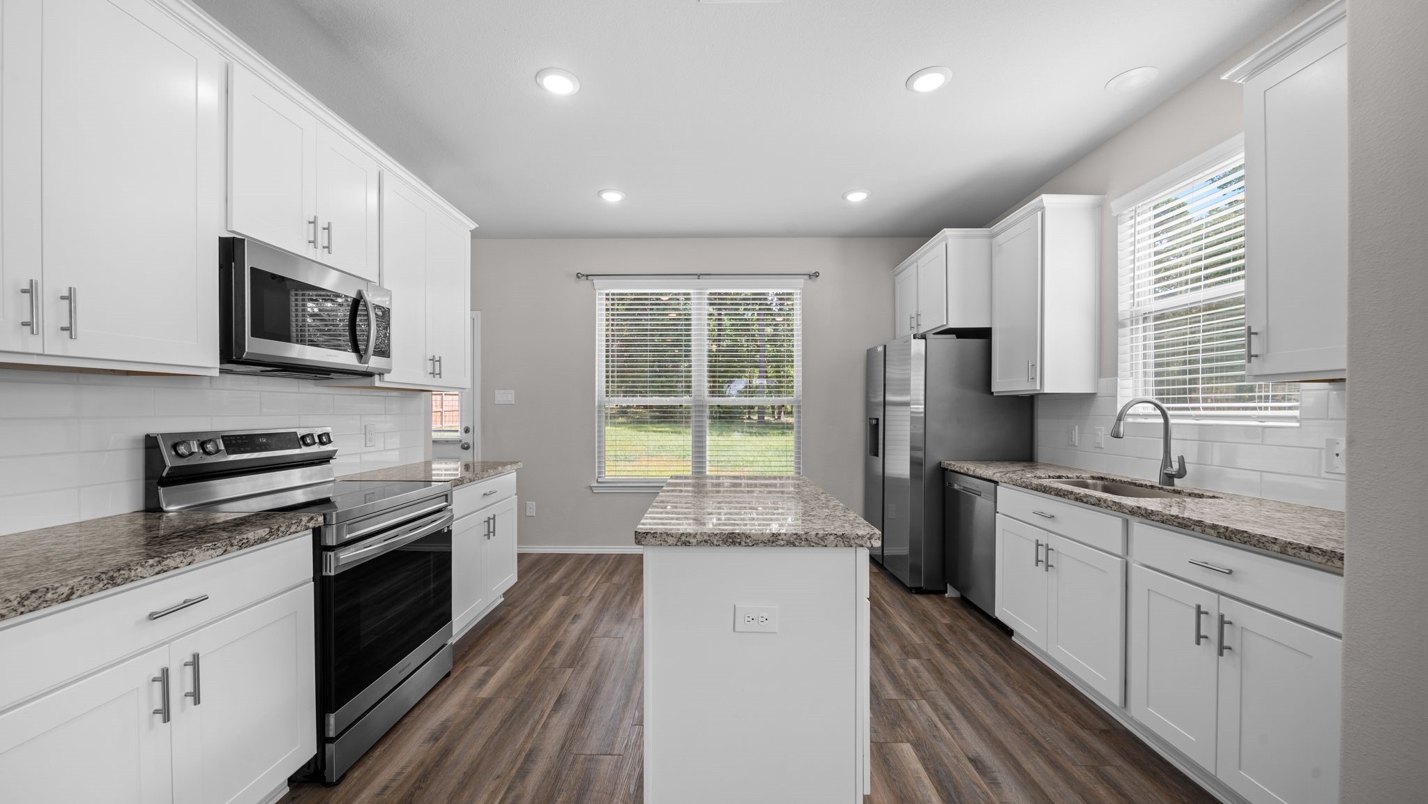 18140 Mail Rte Road Montgomery, TX 77316 - Photo 8 of 26 Beautiful kitchen featuring white shaker cabinetry, granite countertops, stainless steel appliances, and a spacious center island.