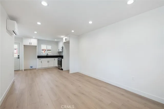 wooden floor in an empty room with a kitchen