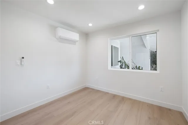 a view of small space with wooden floor and fan