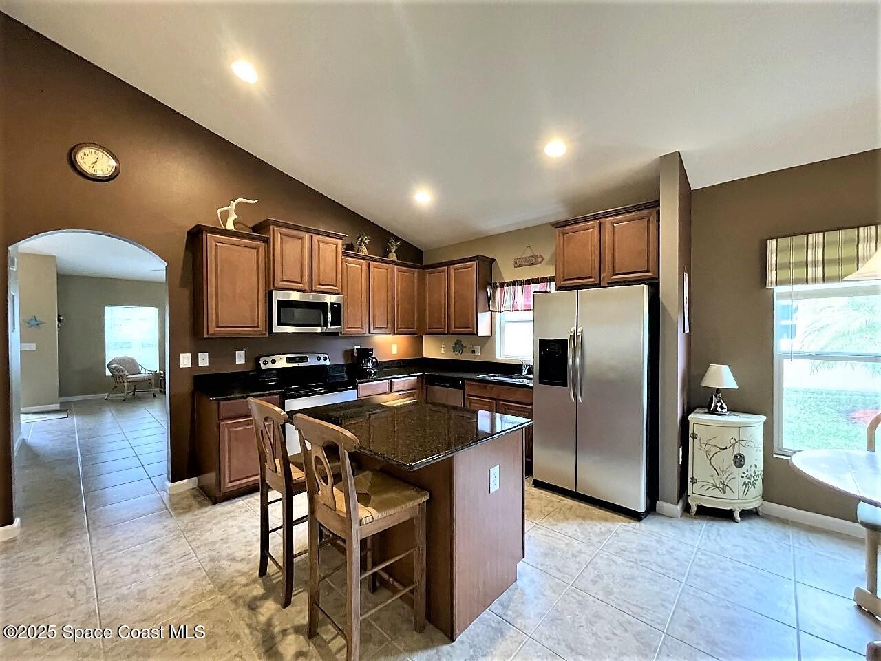 217 Briarcliff Circle Sebastian, FL 32958 - Photo 23 of 36 a kitchen with stainless steel appliances granite countertop a refrigerator a stove a sink a dining table and chairs