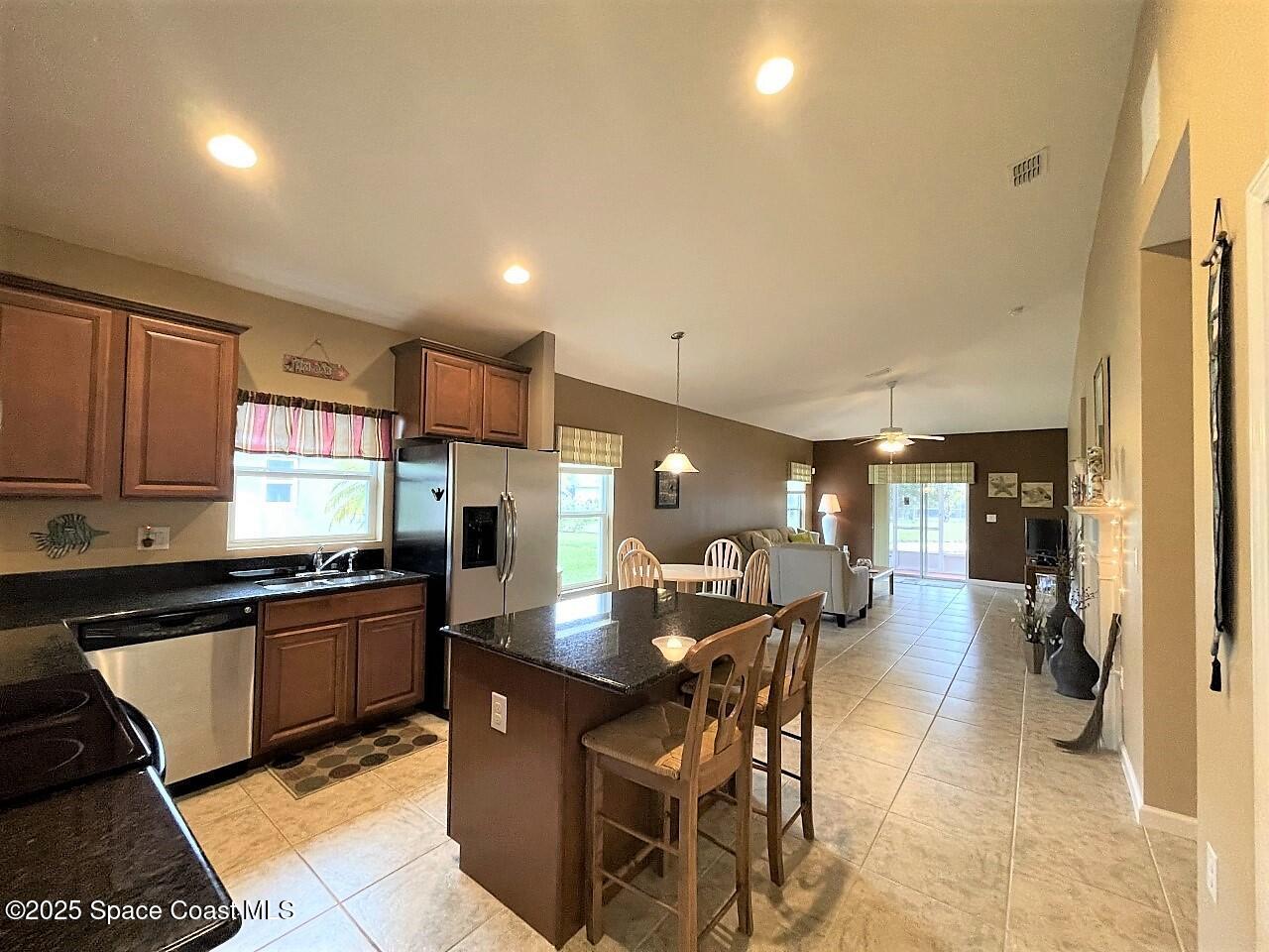 217 Briarcliff Circle Sebastian, FL 32958 - Photo 24 of 36 a kitchen with lots of counter top space and center island dining table chairs