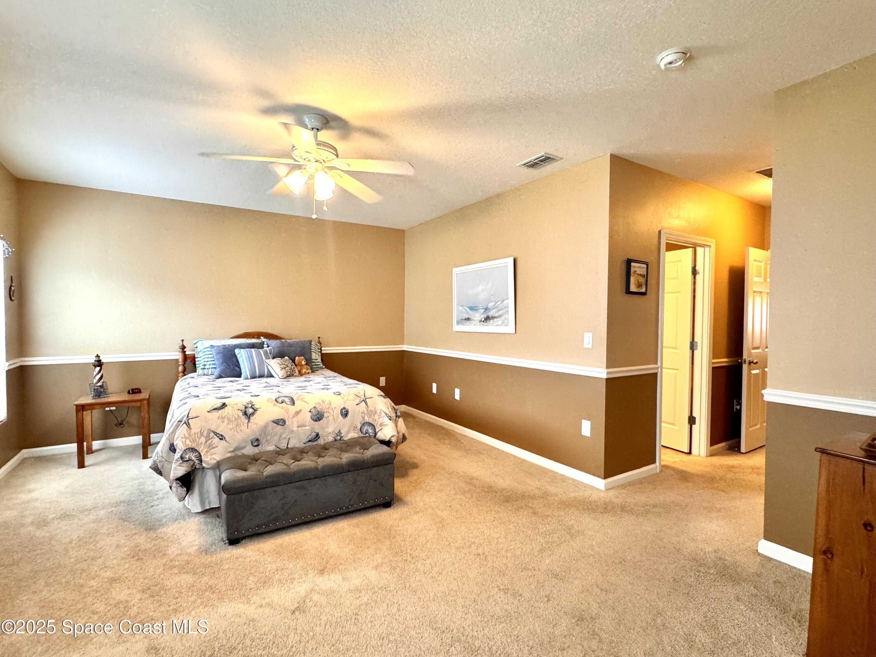 217 Briarcliff Circle Sebastian, FL 32958 - Photo 27 of 36 a bedroom with a bed and a chandelier