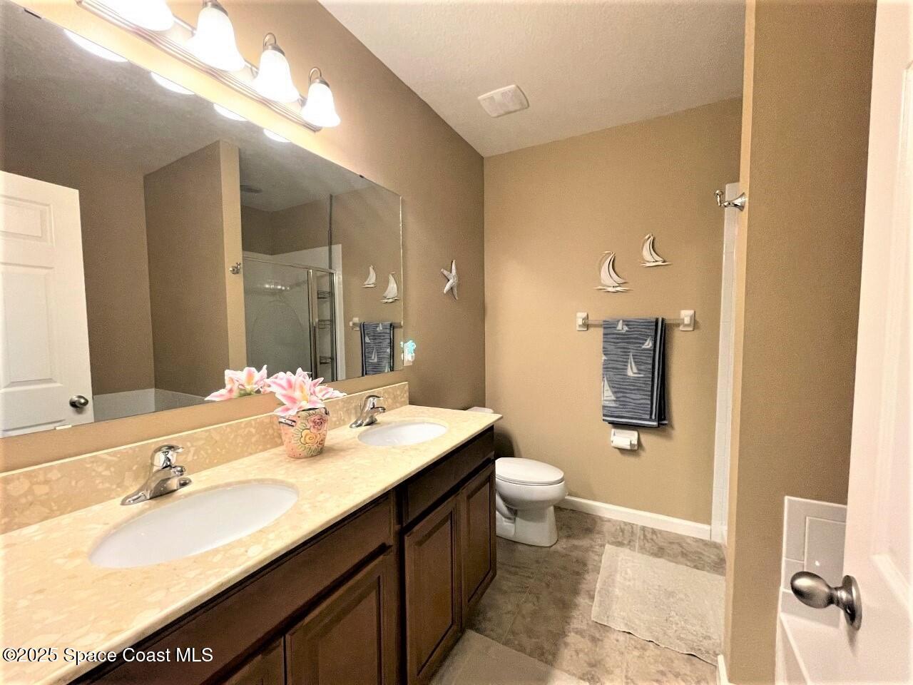 217 Briarcliff Circle Sebastian, FL 32958 - Photo 30 of 36 a bathroom with a double vanity sink toilet mirror and shower