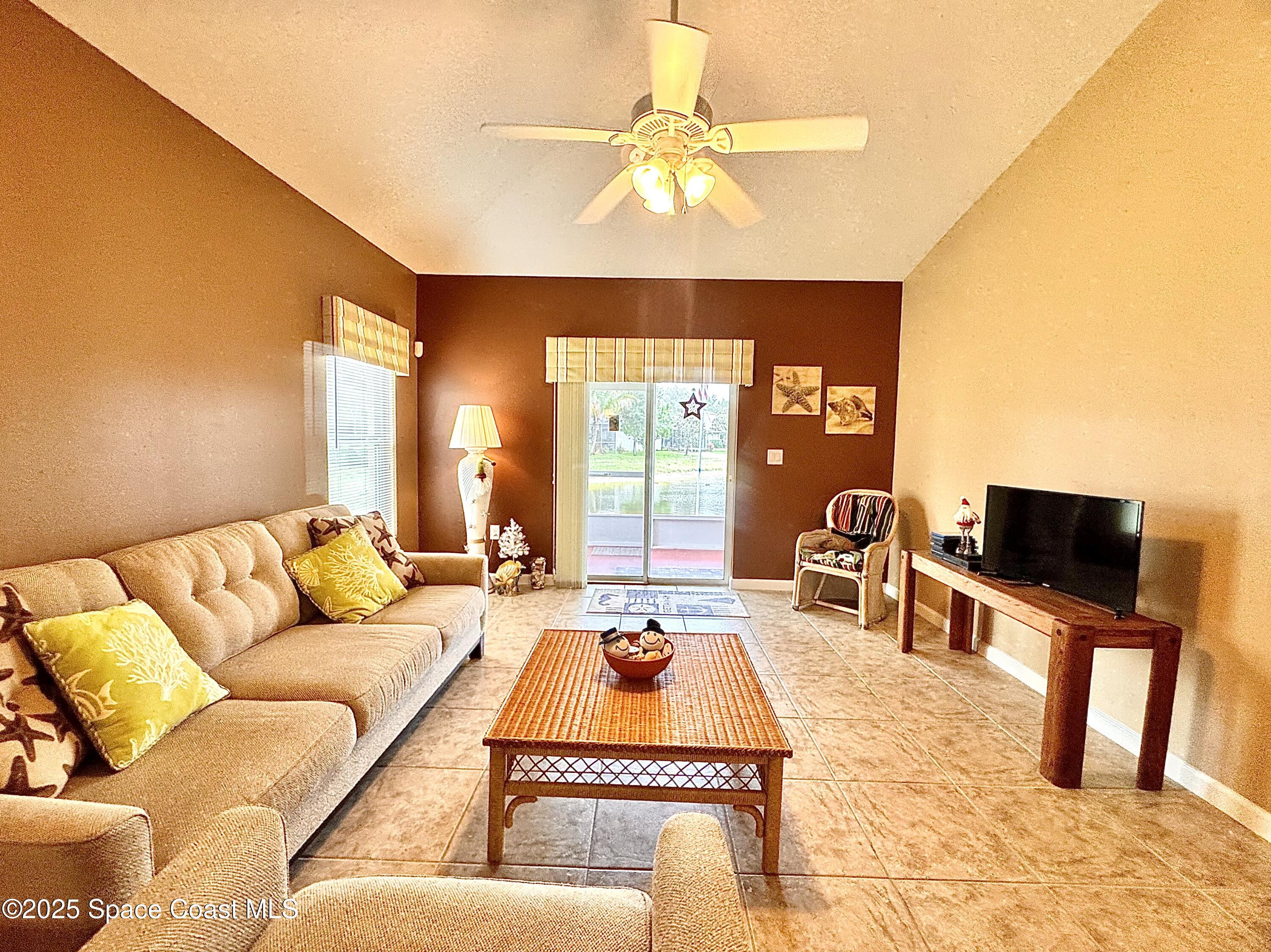 217 Briarcliff Circle Sebastian, FL 32958 - Photo 35 of 36 a living room with furniture a large window and a flat screen tv