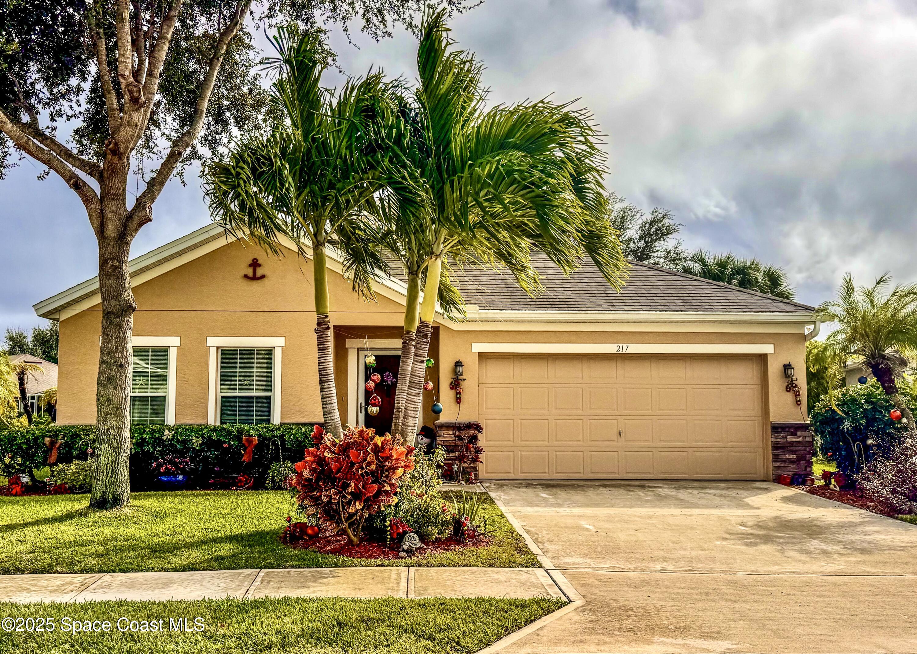 217 Briarcliff Circle Sebastian, FL 32958 - Photo 5 of 36 a front view of a house with a garden and trees